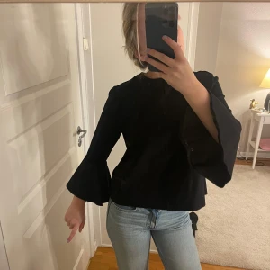 Svart blus med vida ärmar - Säljer en stilren svart blus med vida ärmar. Perfekt för både vardag och fest! Blusen har en lös passform och är superbekväm. Storlek S💕💕