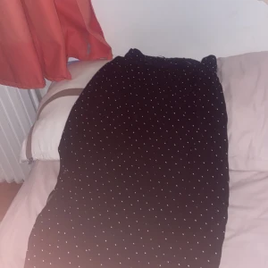 Svart prickig långkjol - Säljer en svart långkjol med vita prickar från 157. Kjolen har en bekväm passform och är perfekt för både vardag och fest. Den är i mycket bra skick och passar bra till olika toppar och skor. Perfekt för höst och vår!