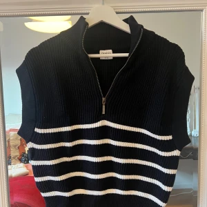 Svart och vit randig väst från Shein - Snygg svart stickad väst från Stories med vita ränder och dragkedja framtill. Perfekt för lager-på-lager under höst och vår. Den har en ribbad struktur och är i mycket bra skick. Passar både till vardags och festliga tillfällen.