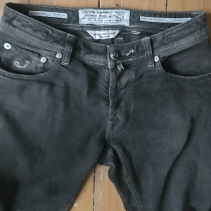 Gråa jeans från Jacob Cohen - Säljer ett par snygga gråa jeans från Jacob Cohen. De har en klassisk femficksdesign med knappar och en stilren look. Perfekta för både vardag och fest!