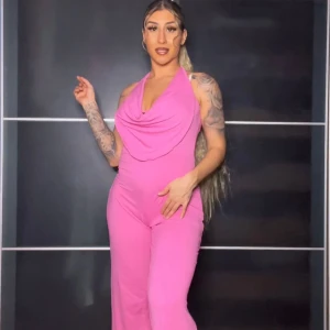 Rosa jumpsuit | OANVÄND  - Säljer en superfin rosa jumpsuit med halterneck och draperad framsida. Perfekt för festliga tillfällen! Den är tight upptill och har vida ben, vilket ger en snygg siluett. Materialet är mjukt och stretchigt för bästa komfort. Passar perfekt för sommarens alla fester! 💖passar S och M.