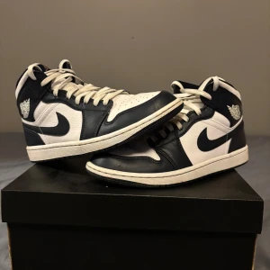Nike Air Jordans i svart och vit - Säljer ett par klassiska Nike Air Jordans i svart och vit. Skorna har en snygg hög design med snörning och är i mycket bra skick. Perfekta för både vardag och fest! 🖤🤍