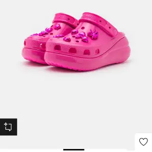 Supercoola rosa Crocs med glittriga dekorationer på ovansidan. Perfekta för att liva upp vilken outfit som helst! De är bekväma och lätta att bära, med en klassisk Crocs-design och justerbar hälrem. Perfekta för sommarens alla äventyr! 💖