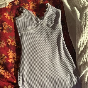 Ljuslila ribbad klänning från Divided - Säljer ett supersött ljuslila ribbad klänning från Divided. Det har spetsdetaljer vid halsringningen och en liten rosett framtill. Perfekt för sommardagar eller som ett lager under en tröja. Använd ett par gånger men i mycket bra skick!