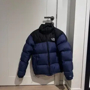 Säljer en snygg blå och svart pufferjacka från The North Face.  I nyskick om man bortser från lagningen på höger arm (se bild 3). Skickas samma dag som köp, pris kan diskuteras vid snabb affär.