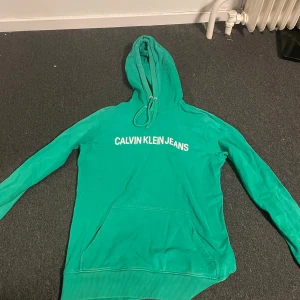 Grön hoodie från Calvin Klein Jeans - Säljer en  grön hoodie från Calvin Klein Jeans. Aldrig använt den så den är i bra skick  