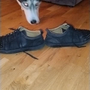 Louboutins - Säljer ett par svarta snygga Louboutins  som är I ganska bra  skick. De har coola nitar på tån och en röd sula som ger en snygg kontrast. Skorna har bara leggat och damat I gadderoben Strlk /41,5-42,5