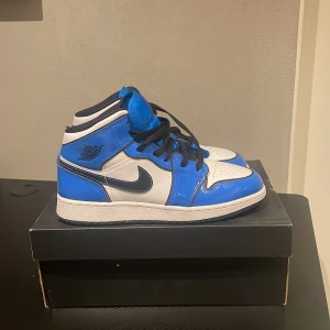 Air Jordan 1 mid Signal blue - Säljer dessa snygga Air jordan 1 mid signal blue! Knappt använda! Har blivit för små för mig så därför jag säljer. Nypris 2899, Mitt pris 1599. Såklart dem är riktiga och köpta på restocks.net:)