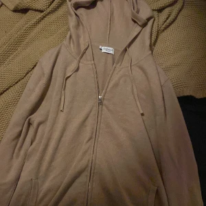 Beige hoodie från Zadolo - Säljer en supermjuk beige hoodie från Zadolo i storlek XS. Perfekt för mysiga höstkvällar eller som ett extra lager under vintern. Den har en dragkedja framtill och en skön huva med dragsko. Passar både till vardags och chill hemma. 🧥✨