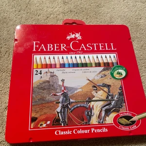 Faber-Castell Classic Colour Pencils 24-pack - Säljer ett set med 24 färgpennor från Faber-Castell i en snygg röd metallåda. Pennorna är perfekta för att skapa starka och briljanta färger. Lådan har ett coolt riddarmotiv på framsidan och är lätt att ta med sig. Perfekt för både hobby och professionellt bruk! Pennorna är inte vässade men man kan gör det själv ganska snabbt💫🔥⭐️