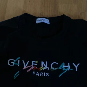 Svart t-shirt från Givenchy - Säljer en  svart t-shirt från Givenchy med färgglatt broderat logotyp på framsidan. Bra skick, använd fåtal gånger 