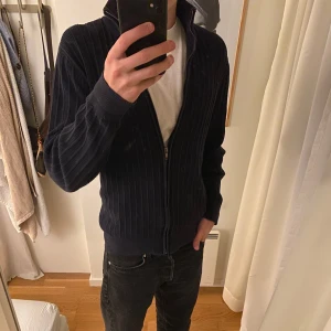 Mörkblå full zip från Dressmann - Säljer en snygg mörkblå stickad tröja från Dressmann i storlek S. Tröjan går inte längre att få tag i, och är i helt 8/10 skick. Riktigt go och perfekt till vintern. Nypris ligger runt 600, mitt pris: 299, men går såklart att diskutera!