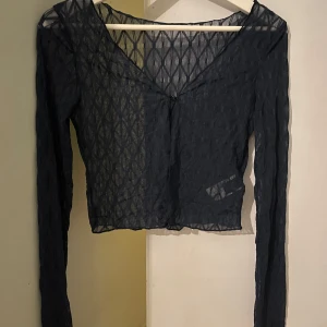 Marinblå söt enkel kofta - Snygg marinblå transparent kofta med lång ärm och v-ringning. Perfekt för lager-på-lager-stil eller som statement-plagg. Den har ett diskret mönster som ger en extra touch.