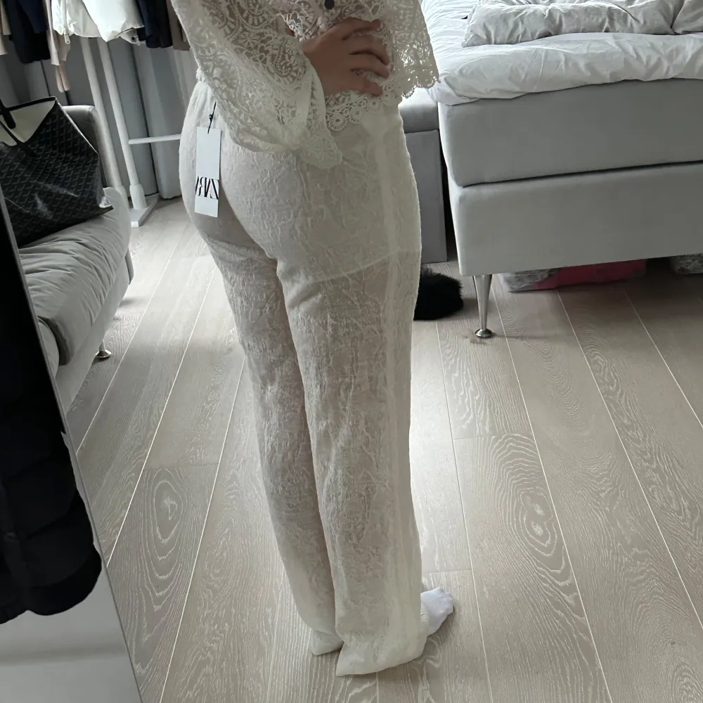 Snygga vita byxor i spets från Zara med elastisk midja och knytband. Perfekta för en somrig look med sitt lätta och luftiga material. Byxorna har en loose passform och är tillverkade i 70% ull och en blandning av nylon och viskos. Nypris 699kr. Farkut & Housut.