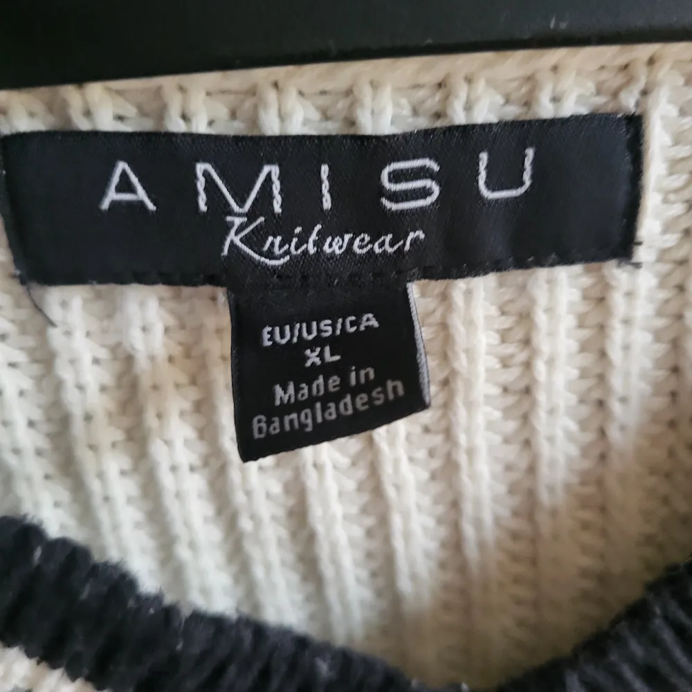 Säljer en snygg vit stickad tröja från Amisu med svarta ränder vid v-ringningen och nederkanten. Tröjan har en avslappnad passform och långa ärmar, perfekt för kyligare dagar. Storlek XL men passar S/M som oversize. . Neuletakit & Villapaidat.