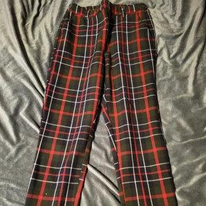 Rutig byxa från ONLY - Snygga rutiga byxor från ONLY i svart, rött och vitt. Byxorna har en elastisk midja för extra komfort och en klassisk rutig design som passar perfekt för höst och vinter.