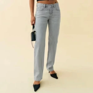 Jeans Grå  - Snygga grå jeansbyxor med låg midja och straight passform. Perfekta för en stilren look. De har klassisk femficksdesign och knappgylf. Från Gina tricot