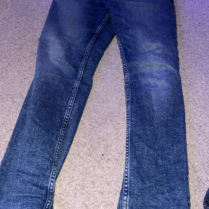 Blå jeans från Tommy Hilfiger - Snygga blå jeans från Tommy Hilfiger med klassisk design. Perfekta för en stilren look. De har en bekväm passform och är tillverkade i slitstarkt denim.