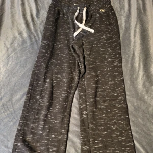 Svarta mjukisbyxor från Champion - Säljer ett par svarta mjukisbyxor från Champion med vita snören i midjan. Byxorna har en loose passform och är perfekta för en avslappnad stil. De är tillverkade i ett mjukt material som ger en bekväm känsla.