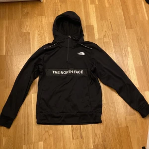 The north face Hoodie  - Säljer en svart hoodie från The North Face med logga på bröstet och ryggen. Tröjan har en justerbar huva och långa ärmar, perfekt för kyliga dagar. Så gott som ny helt utan defekter.