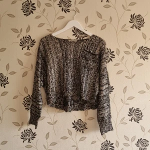 Svart och vit glittrig stickad tröja från Oxygene - Säljer en snygg svart och vit stickad tröja från Oxygene med glittriga detaljer. Tröjan är croppad med en bröstficka och har långa ärmar. Perfekt för att ge lite extra stil till din outfit!