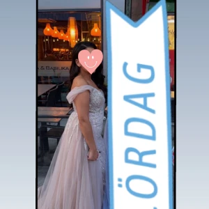 Champagnefärgad långklänning - Elegant champagnefärgad långklänning med glittrigt mönster och offshoulder-design. Klänningen har en vacker omlott-detalj och en lång, flytande kjol som ger en lyxig känsla. Bandet är ett tillägg man kan justera den som offshoulder eller ett linne.            (Köpt på proms and weedings i Malmö, klänning är limited edition som inte finns och köpa,märket är catwalk vilket är ett känt märke för lyxiga klänningar.) ORDPRIS:7000, ‼️Använd endast en gång i några timmar.