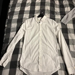 Vit skjorta från Calvin Klein Jeans - Säljer en stilren vit skjorta från Calvin Klein Jeans i extra slim fit. Skjortan har långa ärmar och knappar framtill. Perfekt för en elegant look.