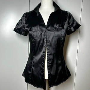 Svart satinblus / tajt skjorta  - Superfin figursydd skjorta/topp från zara. Storlek s. Köp sker via köp nu, jag postar inom 24h. Kvar tills markerad såld 