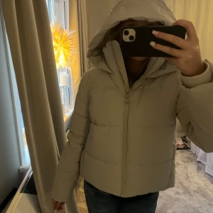 Vit  pufferjacka med huva - Säljer en snygg ljusbeige/vit pufferjacka med huva. Jackan har en dragkedja framtill och långa ärmar. Perfekt för kyligare dagar. Arm muffar vid öppningen så den är riktigt varm❤️