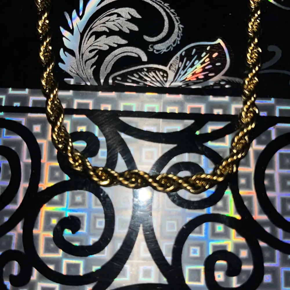 Elegant guldfärgat halsband med en tvinnad design som ger en lyxig känsla. Perfekt för att lyfta vilken outfit som helst. Halsbandet har en säker låsning och en glansig finish. Och passar till allt . Asusteet.