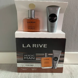 La Rive Heroic Man Eau de Toilette/ Presentask - La Rive Heroic Man Eau de Toilette är en maskulin doft i en elegant glasflaska med silverfärgad kork. Parfymen har en varm och kryddig doftprofil, perfekt för den självsäkra mannen. Flaskan rymmer 100 ml och kommer i en presentförpackning tillsammans med en duschgel.