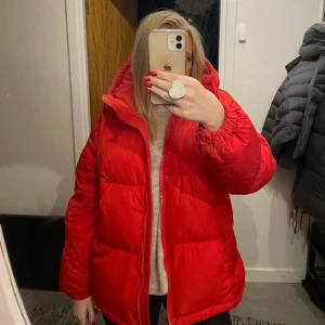 Röd pufferjacka från hm  - Säljer en snygg röd pufferjacka med dragkedja. Jackan har en oversized passform och långa ärmar, perfekt för kyliga dagar. Den är både trendig och bekväm.