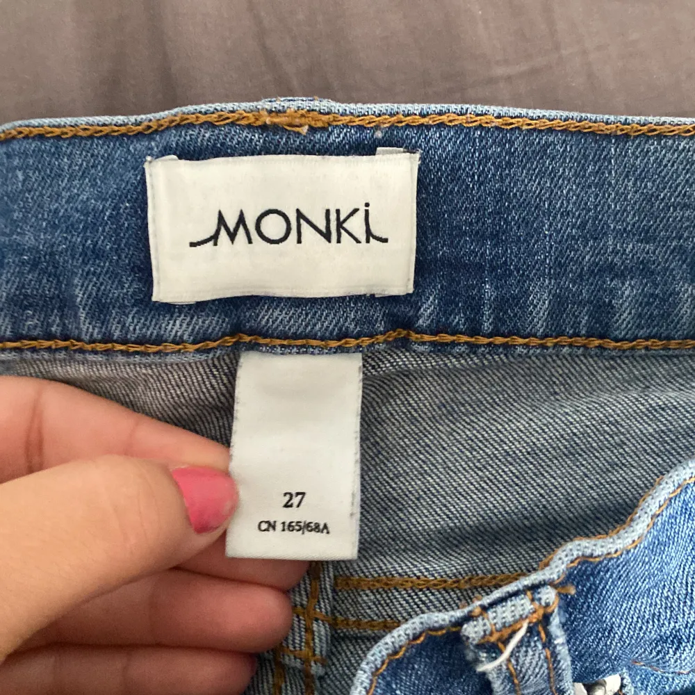 Säljer ett par snygga blå jeansshorts från Monki. De har en cool fransig kant och fina spetsdetaljer på sidorna. Perfekta för sommaren och festivaler! De är i bra skick och redo för nya äventyr. 🦋. Shorts.