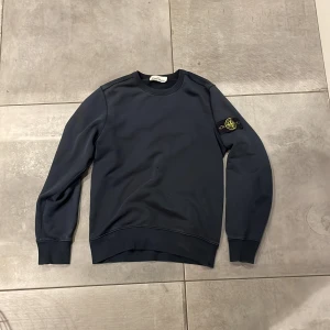 Mörkblå tröja från Stone Island - Säljer en snygg och stilren mörkblå tröja från Stone Island. Tröjan är i bra skick förutom 2 små hål vid magen, därav priset. Men det är inget som påverkar helhetsintrycket. Tröjan är i storlek S och är bekväm och passar till det mesta! vid funderingar tveka inte på att höra av dig, priset kan diskuteras vid en snabb affär⭐️