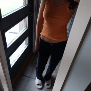 Orange ribbad linne - Säljer en snygg orange ribbad linne som är perfekt för sommaren men också hösten med kofta över. Färgen är supercool som gör den unik.