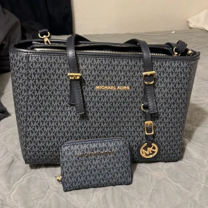 Michael kors väska -  Den har både långa och korta band. Det finns en zip inuti väskan som rymmer massa samt en liten zip på sidan inuti väskan. Den har aldrig använts. Det tillkommer även en matchande plånbok. Den är fejk och är köpt i Turkiet. 