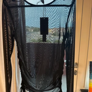 Svart Genomskinlig långärmad tröja  - Svart genomskinlig långärmad tröja från NA-KD  Storlek:M  Har aldrig använt, prislappen hänger kvar 