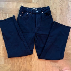 Svarta Ribcage Straight jeans w26 L 27 - Säljer ett par svarta Ribcage Straight jeans i storlek 26. De är högmidjade och har en klassisk straight fit. Perfekta för både vardag och fest!  Mkt gott anbönt skick! 