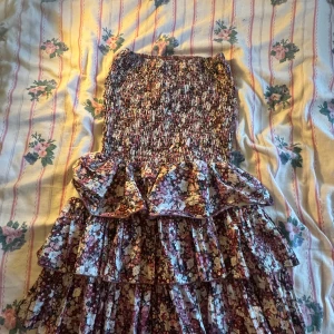 Blommig ärmlös topp med volang - Säljer en superfin blommig tub klänning med volangdetaljer. Den är ärmlös och har en tight passform som är perfekt för sommaren. Var min mammas i 2000 talet och har inte använt den sen jag fick den, då den ligger i ny skick. pris kan diskuteras 🎀🎀💗
