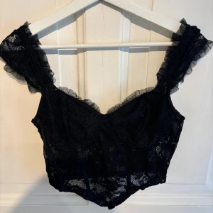 Festtopp korsettliknande i spets  - Skit snygg tröja som tyvärr va för liten för mig. Perfekt till fest, lite korsettliknande i spets. Storlek M, köparen står för frakten <3