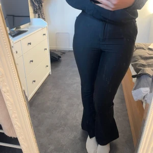 Svarta byxor från Nelly x Glamorous - Säljer ett par svarta byxor från Nelly x Glamorous i storlek M. De är högmidjade och har en snygg bootcut-stil som ger en modern look. Perfekta för både vardag och fest!🩷