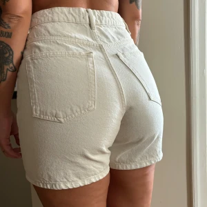 Denim shorts från Lindex - Shorts med hög midja i beige denim från Lindex i storlek 38. Har tyvärr aldrig kommit till användning.   Hämtas i Råsunda eller skickas mot fraktkostnad. 
