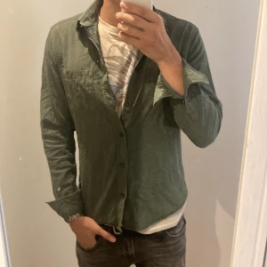 Grön skjorta från Dobber - Säljer en snygg grön skjorta från Dobber i storlek small. Skjortan är långärmad och har en klassisk krage med knappar hela vägen ner. Perfekt för både vardag och fest! Sitter slim och bra på mig som är 180
