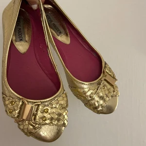 Guldiga ballerina skor - Guldiga ballerinaskor från steve madden, slitna inuti och lite små slitningar på utsidorna (skriv för bilder på defekter) SKA VARA STORLEK 36 MEN VAR FÖR SMÅ FÖR MIG SOM NORMALT HAR DET