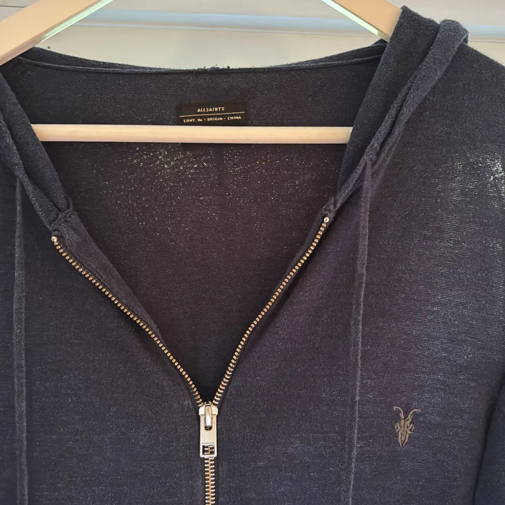 En stickad zip hoodie från märket Allsaints. Den är storlek M men skulle säga att den kan passa S också. Tröjan är i bra skick och fler bilder kan skickas. Pris kan diskuteras!. Hoodies.