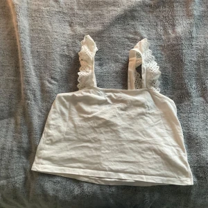 Fint linne från hm - Säljer ett fint linne från hm i bra skick. Linnet är vitt med volanger på axelbanden.