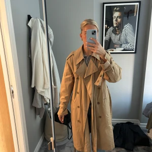 Trenchcoat  - Beige trenchcoat som inte använts många gånger. Medellång med band som går att knyta och knäppa med knapparna på framsidan. Fungerande djupa fickor framtill. Normal/lite baggy fit. Ner till knäna för mig som 170cm lång och vanligtvis storlek S/36 🥰