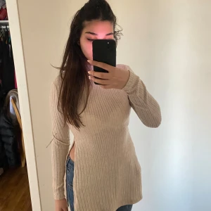 Beige ribbad tröja - Säljer en superfin beige ribbad tröja som är perfekt för höst och vinter. Den har en tight passform och långa ärmar, vilket gör den både stilren och mysig. Perfekt att matcha med jeans eller kjol för en avslappnad look.