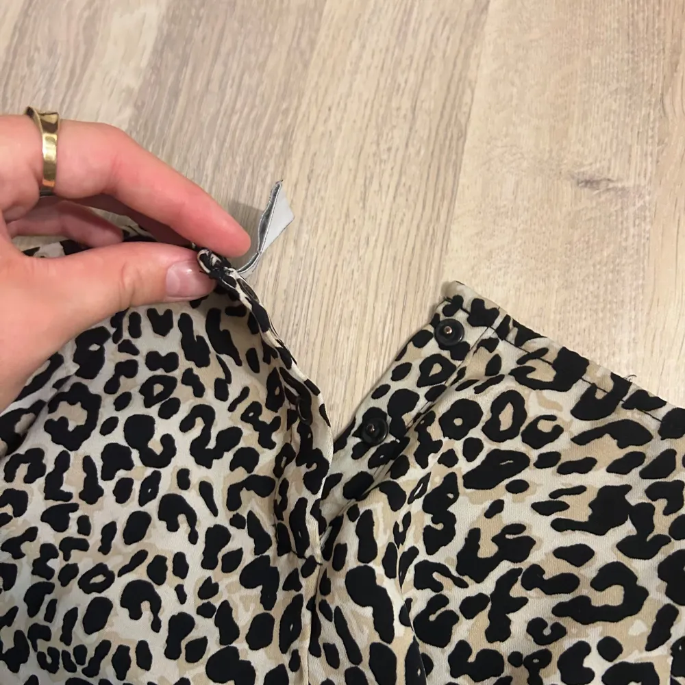 Säljer denna fina leopard topp med trekvartsärmar då den är lite för liten för mig, den är i storlek 146/152 men skulle säga att den sitter som en XS/S. Finns knappar i bak i nacken, se bild 3. Finns samt ett knyte i fram vid midjan. I bra skick. . Puserot.