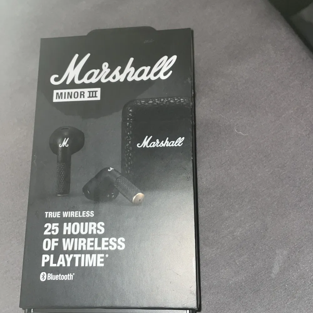 Säljer ett par Marshall Minor III True Wireless hörlurar. De är svarta och kommer med ett snyggt fodral med Marshall-loggan. Hörlurarna erbjuder 25 timmars trådlös speltid och ansluts via Bluetooth. Perfekt för musikälskare som vill ha stil och kvalitet i ett!. Accessoarer.